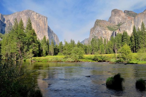 View of a vast valley with a river bordered by majestic mountains and thick forests, Yosemite