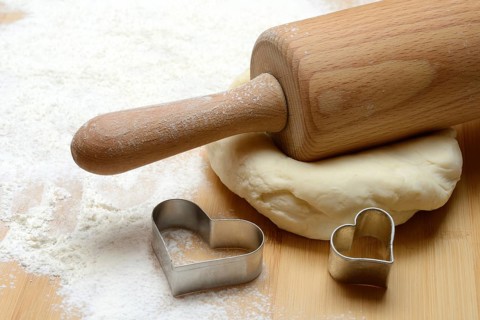 Dough roller on dough and cookie cutter, cake dough