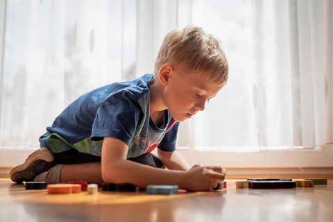 5-6 old boy play with blocks puzzle