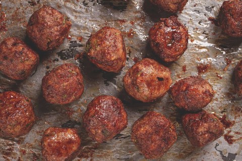 Homemade meatballs cooked to perfection on a baking tray with seasoning and herbs, Swedish