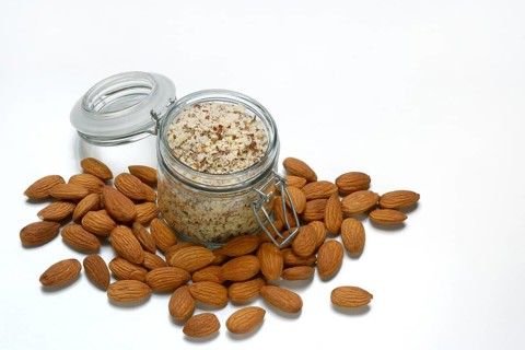 Almonds and ground almonds in glass, Prunus amygdalus