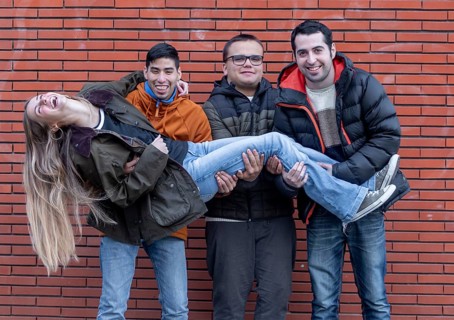A joyful group at a mental health leisure center shares a playful moment as three young men with