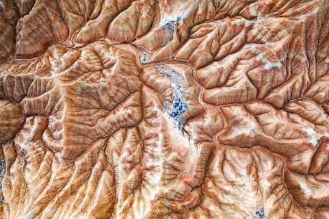 Aerial view of a rugged desert landscape with intricate patterns and natural formations The