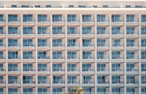 Architectural detail of a modern hotel building featuring a repeated pattern of balconies and