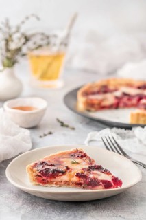 From above tasty fresh slice of quiche with red beet on white plate on served light table indoors