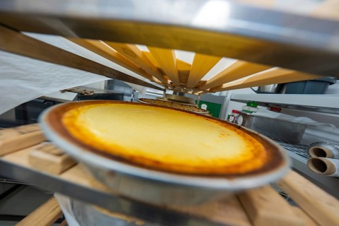 Close-up of cheesecake in tin on wooden structures from an unusual angle
