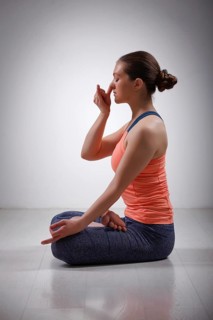 Beautiful sporty fit yogini woman practices pranayama breath control exercise in yoga asana