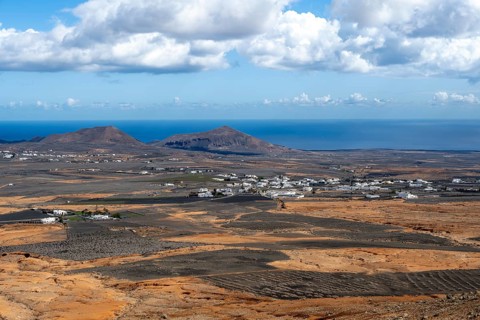Town with white houses in dry volcanic landscape with fields, Lanzarote, Canary Islands, Spain