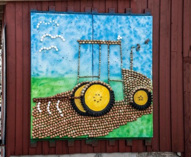 Picture on outdoor wall showing tractor made of many eggs in Olsgård, Tomelilla municipality, Skåne