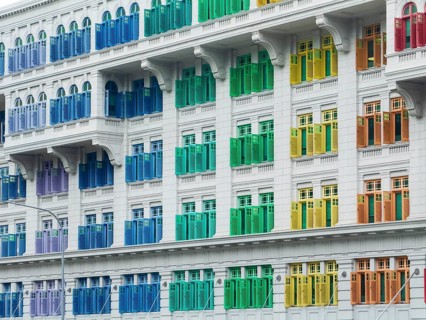 A vibrant facade of a colonial-style building in Singapore, showcasing a row of multicolored