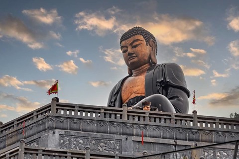 Large Buddha statue in a temple against a cloudy sky, Large Buddha statue at Fansipan in the