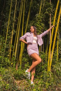 Young caucasian girl with a pink skirt in a bamboo forest. Enjoying the city on summer vacation in