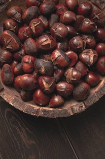 Roasted chestnuts, in a wooden plate, top view, homemade, no people