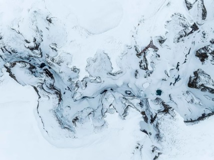 A mesmerizing aerial view of Iceland's Glacier during winter. The snow-covered terrain creates a