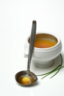 Bouillon, beef broth with ladle in bowl
