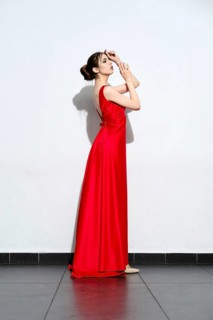 Charming girl in waiving red silk dress with straps