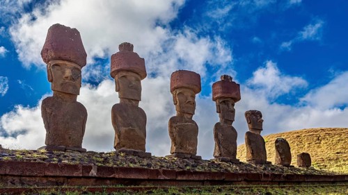 Six Moai statues on stone slab against a blue sky, The Moai statues on Easter Island in the Pacific