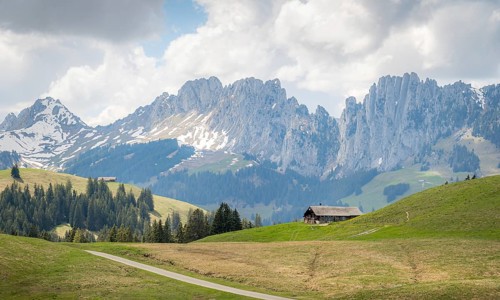 Spring view of a serene landscape in Jaun, Gruyere, featuring the dramatic Gastlosen mountain range