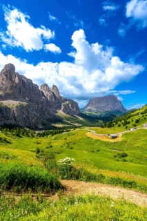 Winding road of passo gardena meandering through the majestic sella group peaks under a vibrant