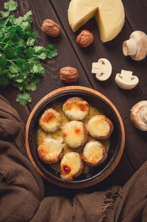 Traditional Georgian dish, appetizer, stuffed mushrooms, Sulguni cheese, baked in a Ketzi clay pan,