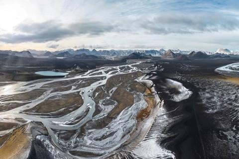 A breathtaking aerial view of Iceland's Highlands, showcasing rugged terrain, winding rivers, and