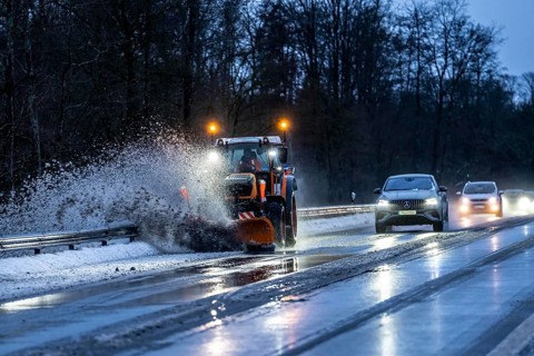 Winter service, spreader and snow plough in use, clears snow and slush from a regional road,