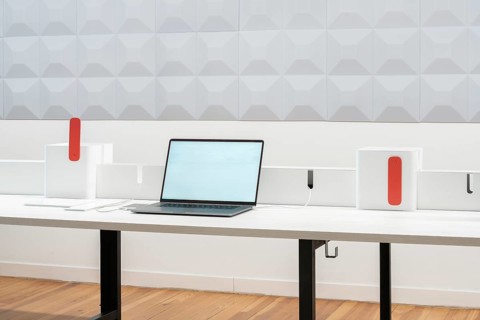 A modern office workspace featuring a laptop on a sleek desk with minimalistic design elements. The