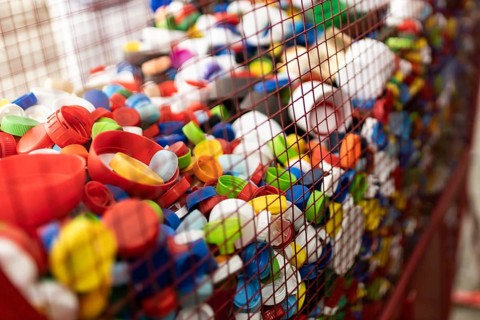 A vibrant array of plastic caps, neatly collected in a cage, showcases the ongoing efforts to