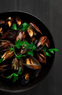 Fresh, Boiled mussels, Black Sea, with parsley and lemon, on a wooden table, no people