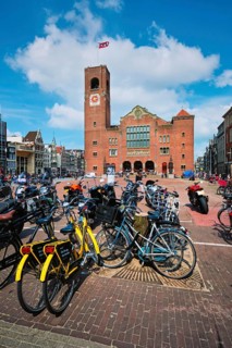 Amsterdam, Netherlands, May 7, 2017: Beursplein with parked bicycles motorcycles and Beurs van