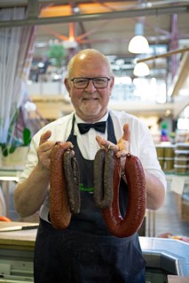 Swedish man, 70 years old, showing Swedish sausages from Helsingborg, Saluhallen, Gothenburg,
