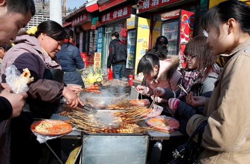 Beijing, CHN, 20.02.09 - Chinese eat meat skewers at a grill stand, CHINA
