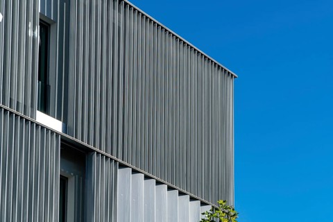 A crisp image highlighting the ribbed facade of a modern building, showcasing a juxtaposition of