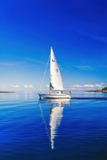 German sailboat with beautiful water reflections on a calm day in the sea archipelago on a sunny