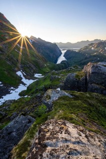 Picturesque mountain landscape at sunrise with sun star, fjord Trollfjord and Raftsund, hike to