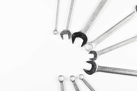 Several wrenches are arranged in a circle on a white background