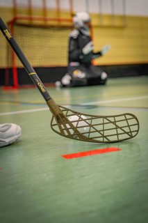 Floorball perspective focusing on the stick, blurred goalkeeper in the background, foolball, Calw,