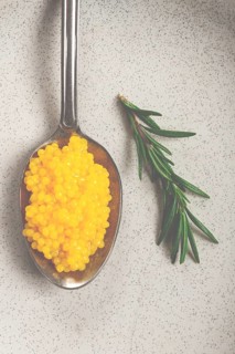 Yuzu caviar is pearly, on a spoon, top view, light background, no people