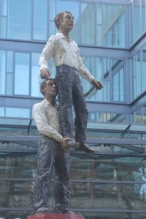 Sculpture Two Men by Stephan Balkenhol 2001, male figure, standing on one leg, carrying, lifting,