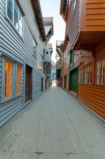 Summer day exploring behind facades in Bryggen Bergen, narrow lanes, colorful wooden buildings,