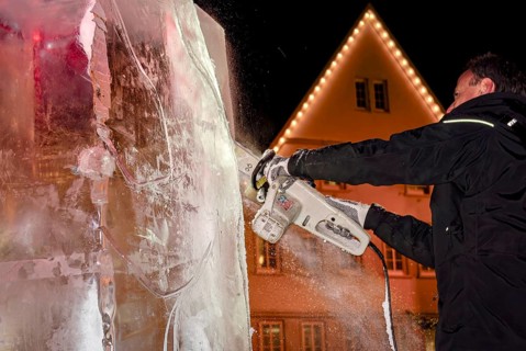 An ice sculpture is being created: ice carving street action as part of the long shopping night in