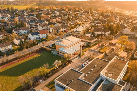 Village view with school building surrounded by residential buildings in autumn scenery,