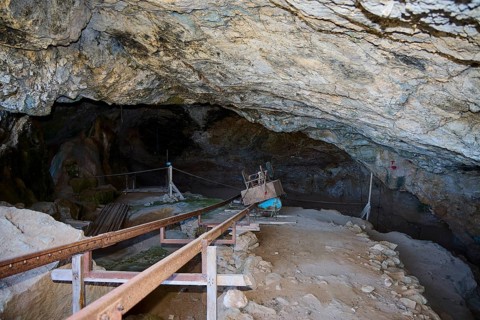 Passageway in a shady cave with walkways and excavation tools, museum, Charkadio Cave, dwarf