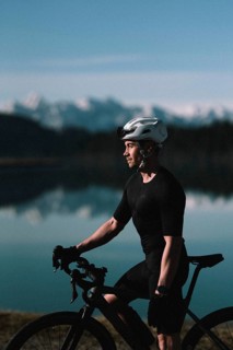 Road bike rider in spring in the Allgäu against the picturesque backdrop of the Alps, Bavaria,