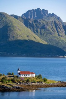 Small church Sildpollnes Kirke at the fjord Austnesfjorden, idyllic Norwegian fjord landscape,