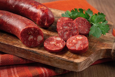 Spicy Chorizo sausage, on a cutting board, on a wooden table