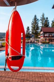 Red lifeguard float on a summer afternoon in an empty pool