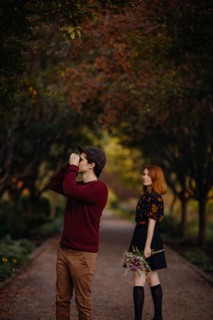 A couple enjoying a beautiful fall day in Quebec, Canada. The woman holds a bouquet of wildflowers,