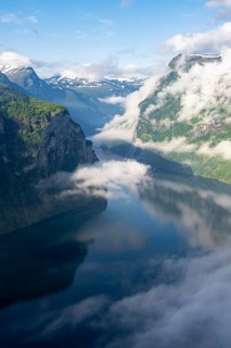Atmospheric clouds over the fjord in the morning light, view of Geirangerfjord, at Ørnesvingen