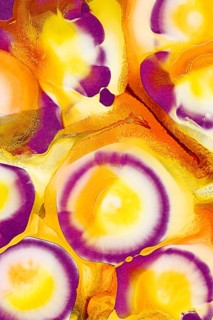 A vivid image showcasing swirling patterns of ink in rich shades of purple, yellow, and orange